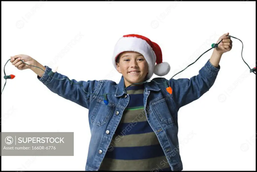 Portrait of a boy holding Christmas lights
