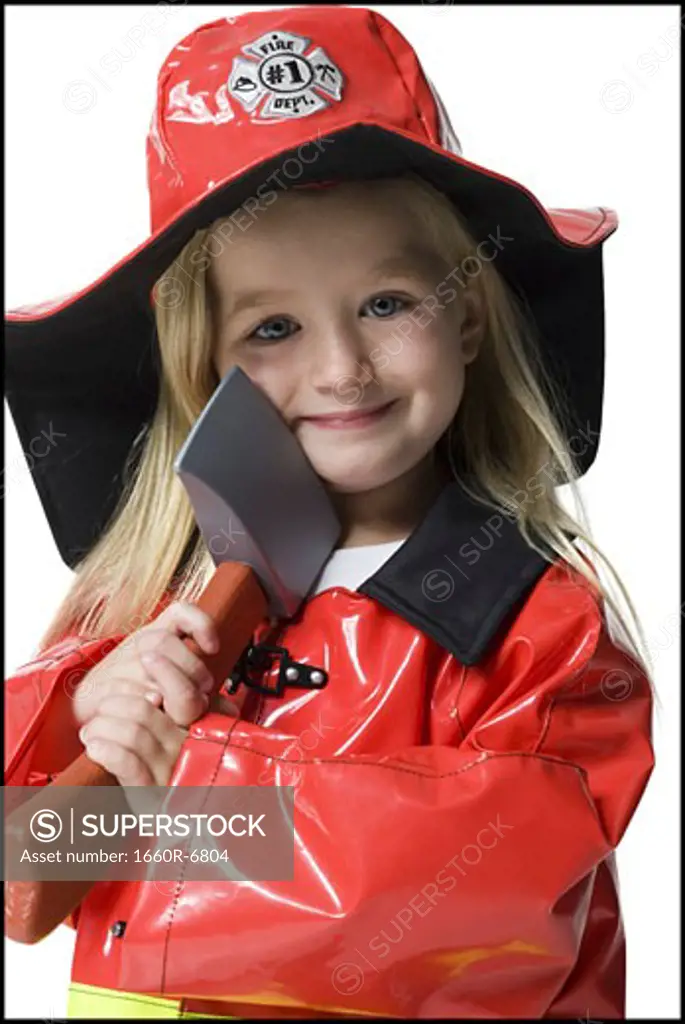 Portrait of a girl dressed as a firefighter and holding an axe