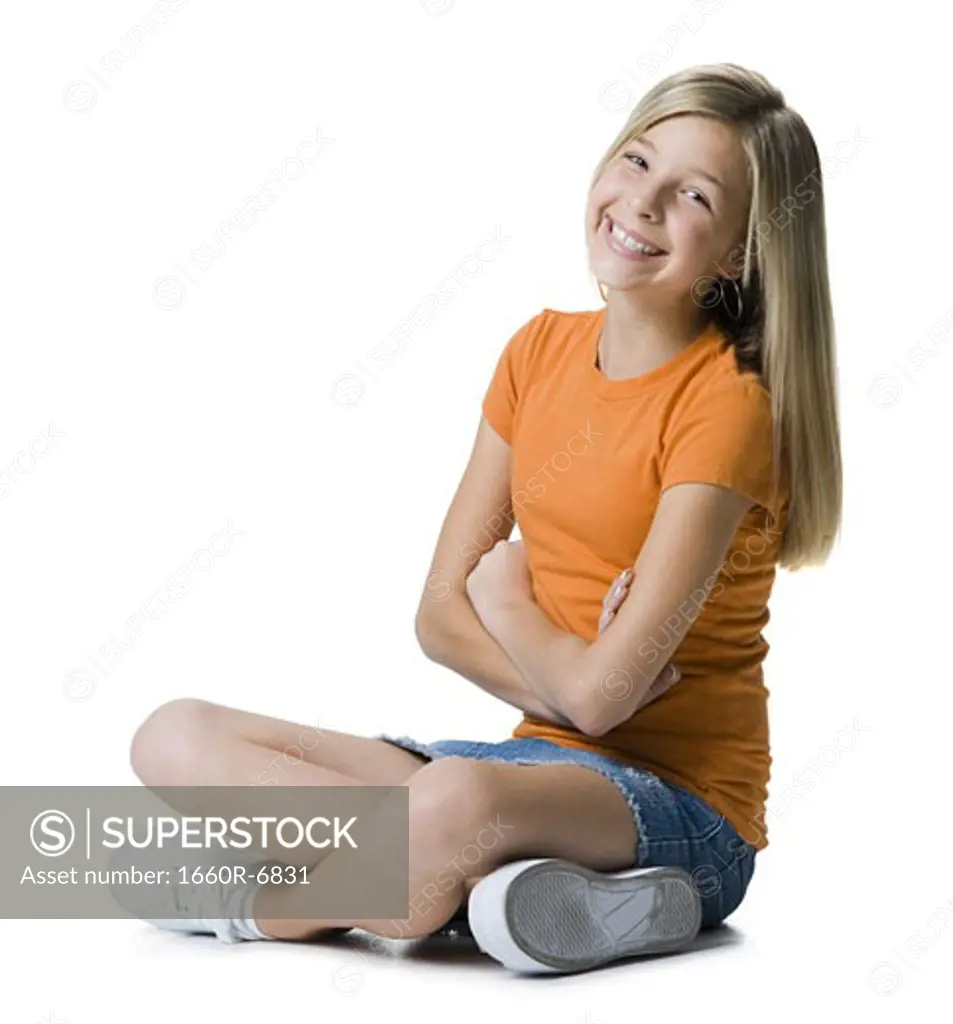 Portrait of a girl sitting cross-legged on the floor and smiling