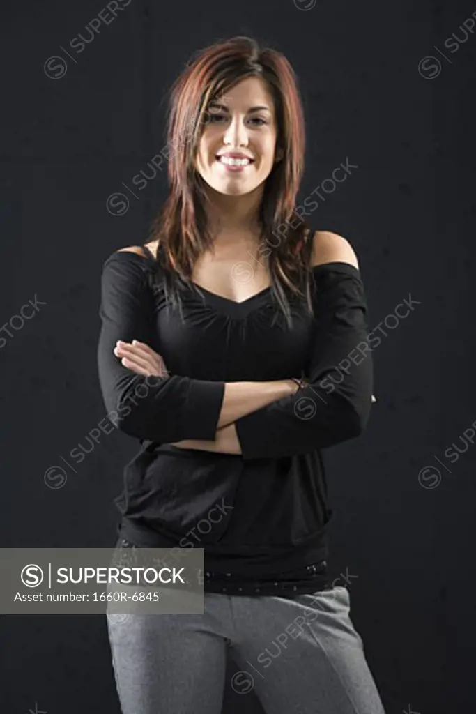 Portrait of a young woman smiling with her arms crossed