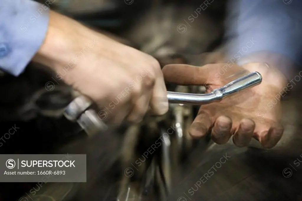 Man giving a spanner to another man