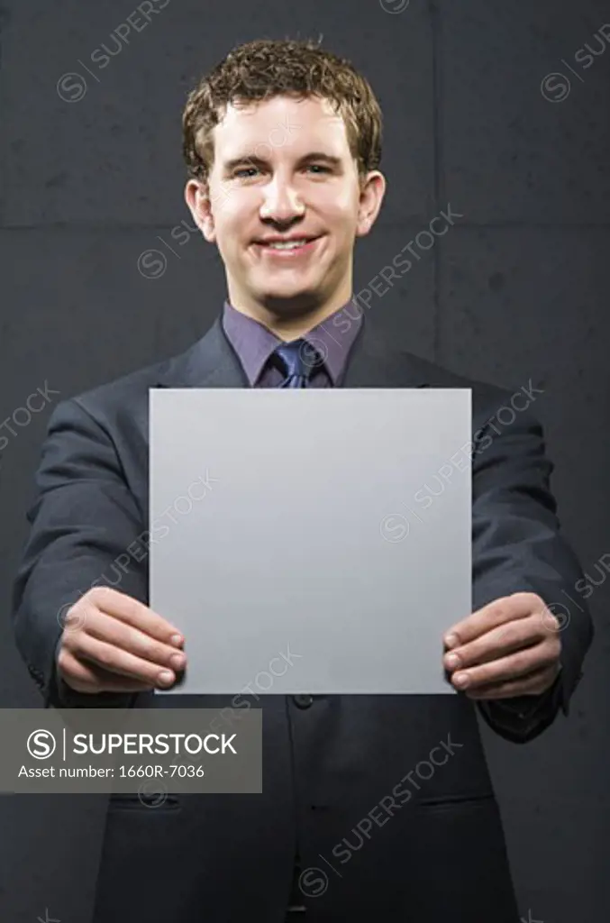 Portrait of a businessman holding a blank sign