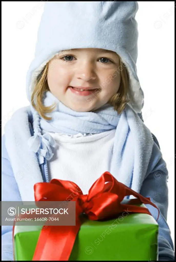 Portrait of a girl holding a gift and smiling