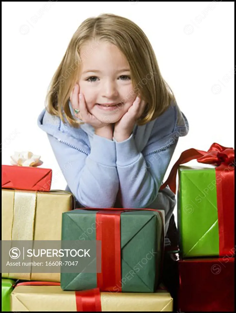 Portrait of a girl leaning over a stack of gifts