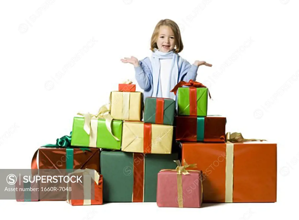 Portrait of a girl standing behind a stack of gifts