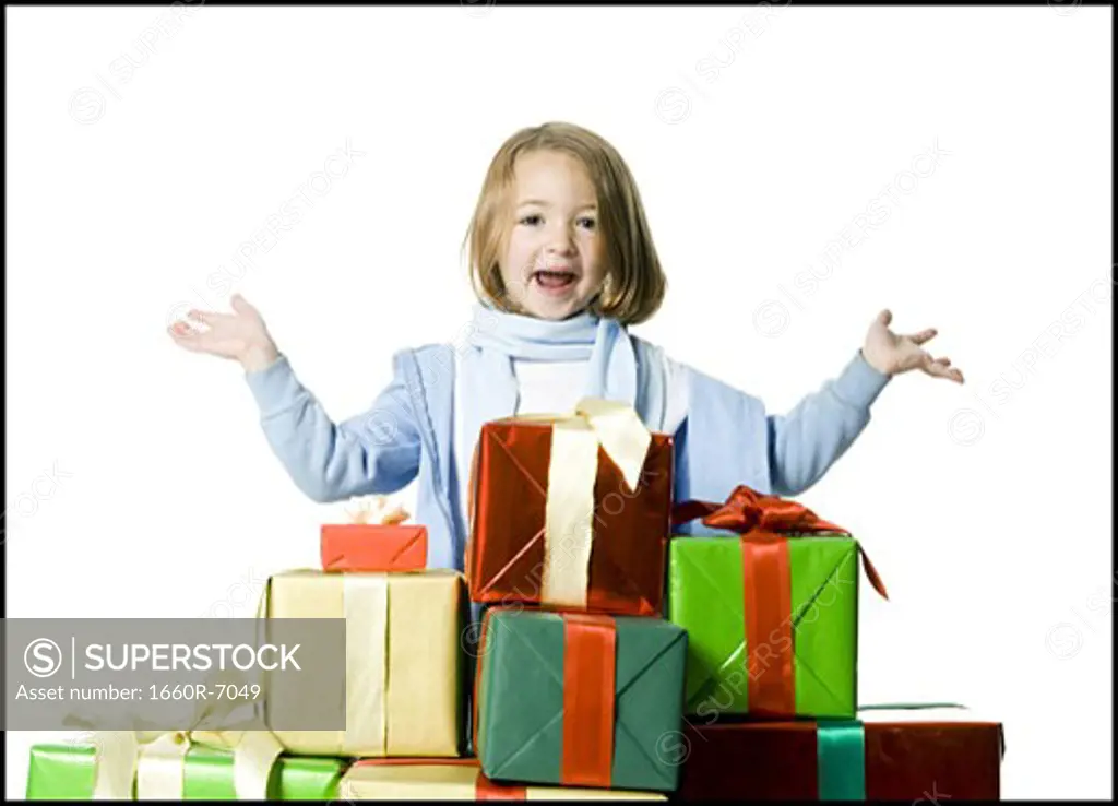 Portrait of a girl standing behind a stack of gifts