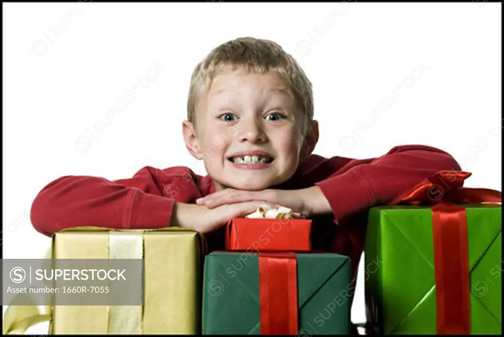 Portrait of a boy leaning over the stack of gifts