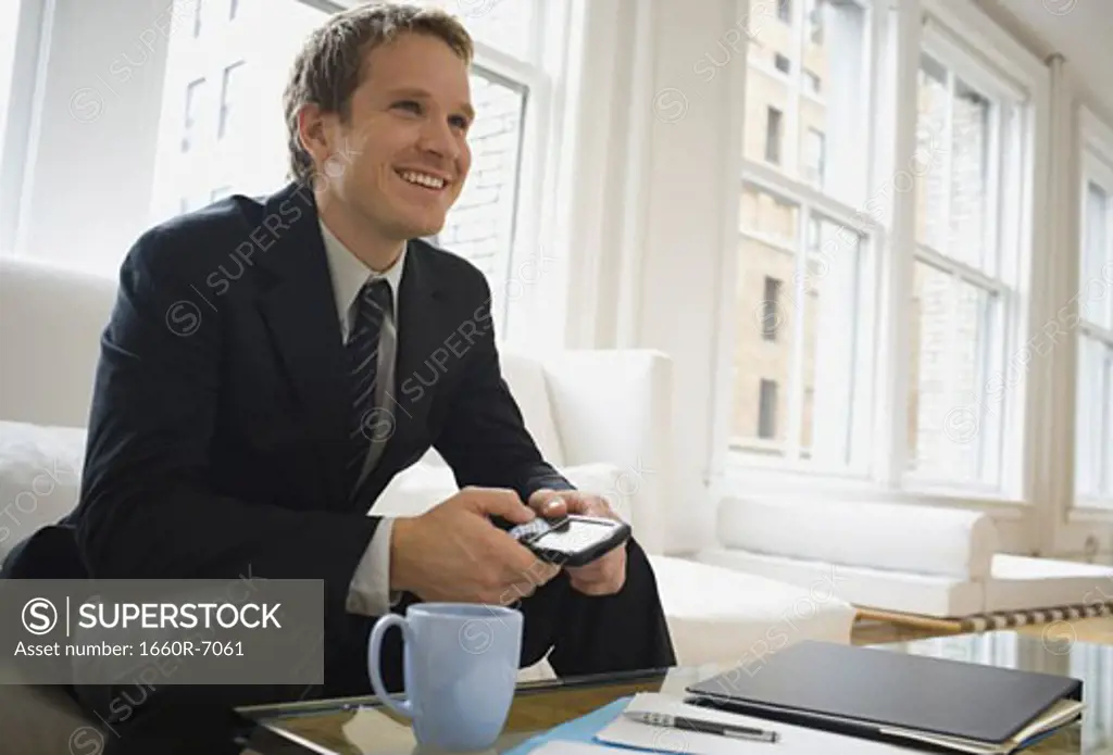 Low angle view of a businessman sitting on a couch and smiling