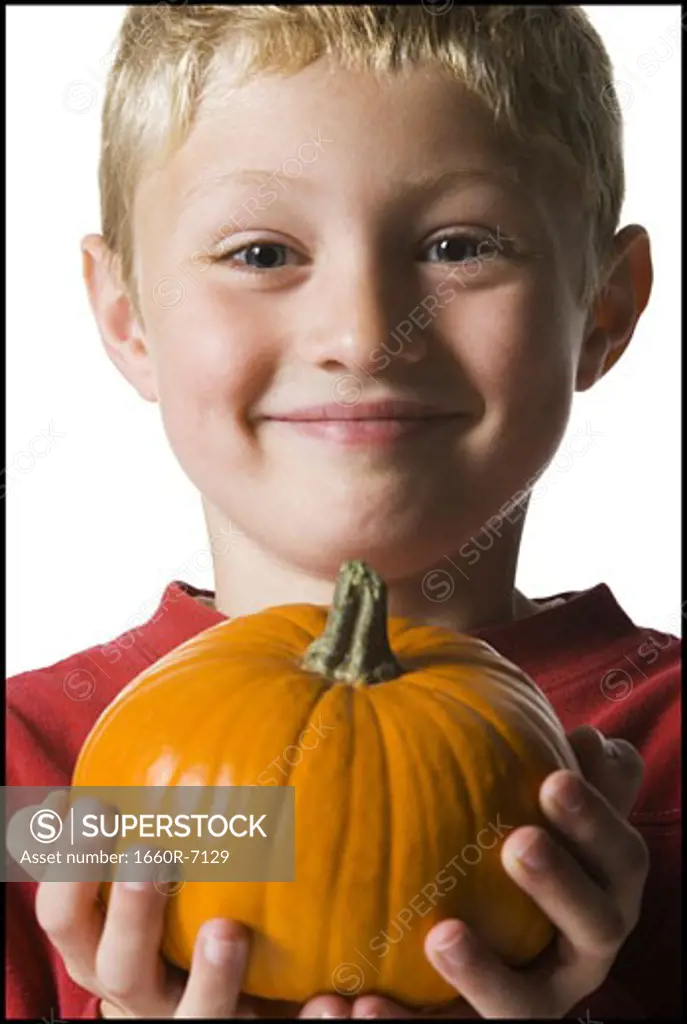 Portrait of a boy holding a pumpkin
