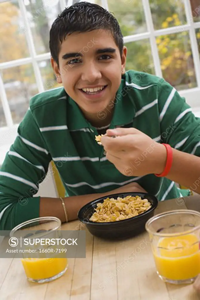 Portrait of a teenage boy eating corn flakes