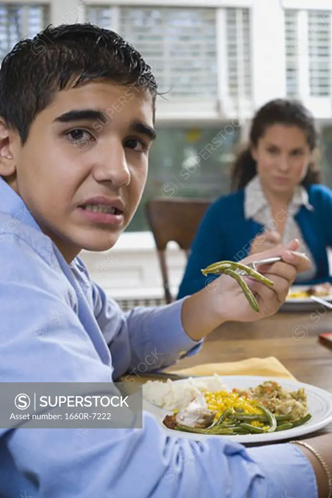 Portrait of a teenage boy sitting at a dining table