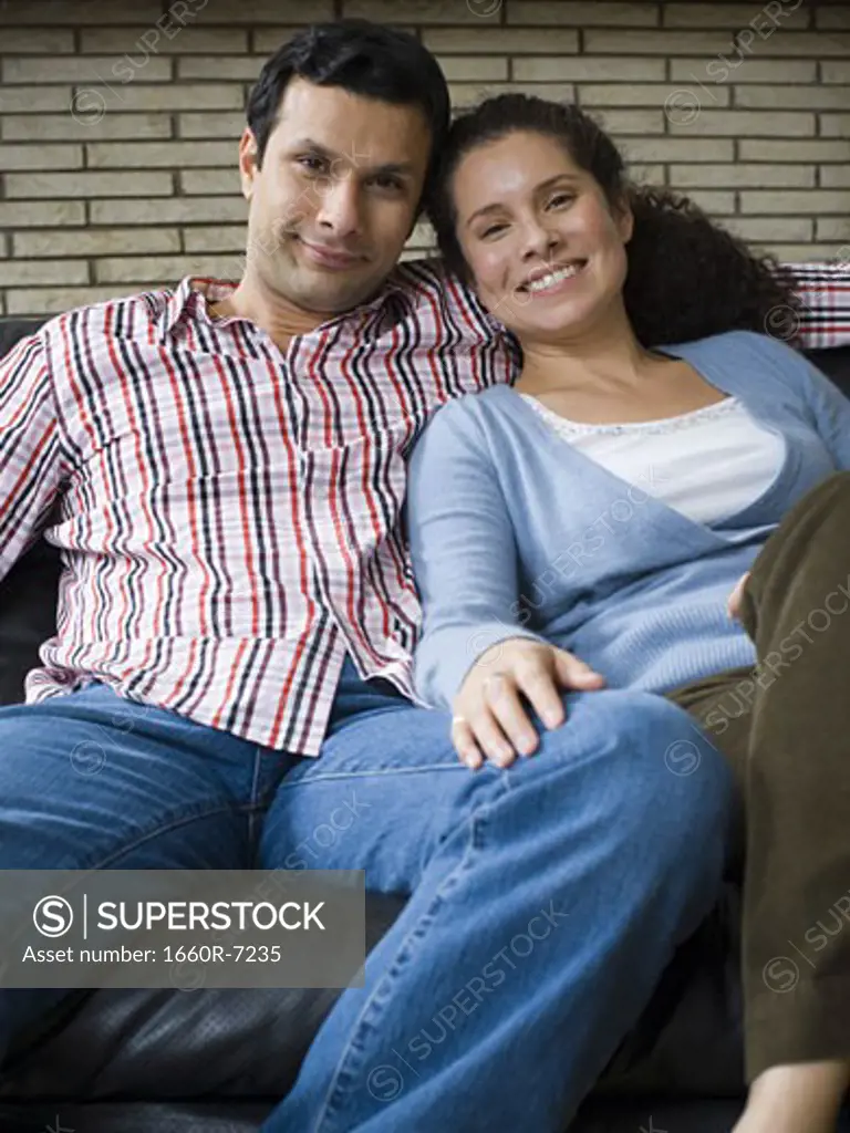 Portrait of a couple sitting on a couch and smiling