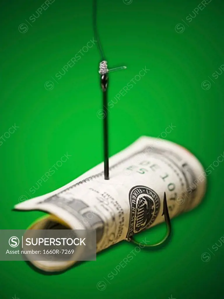 Close-up of an one hundred dollar hanging by a fishing hook