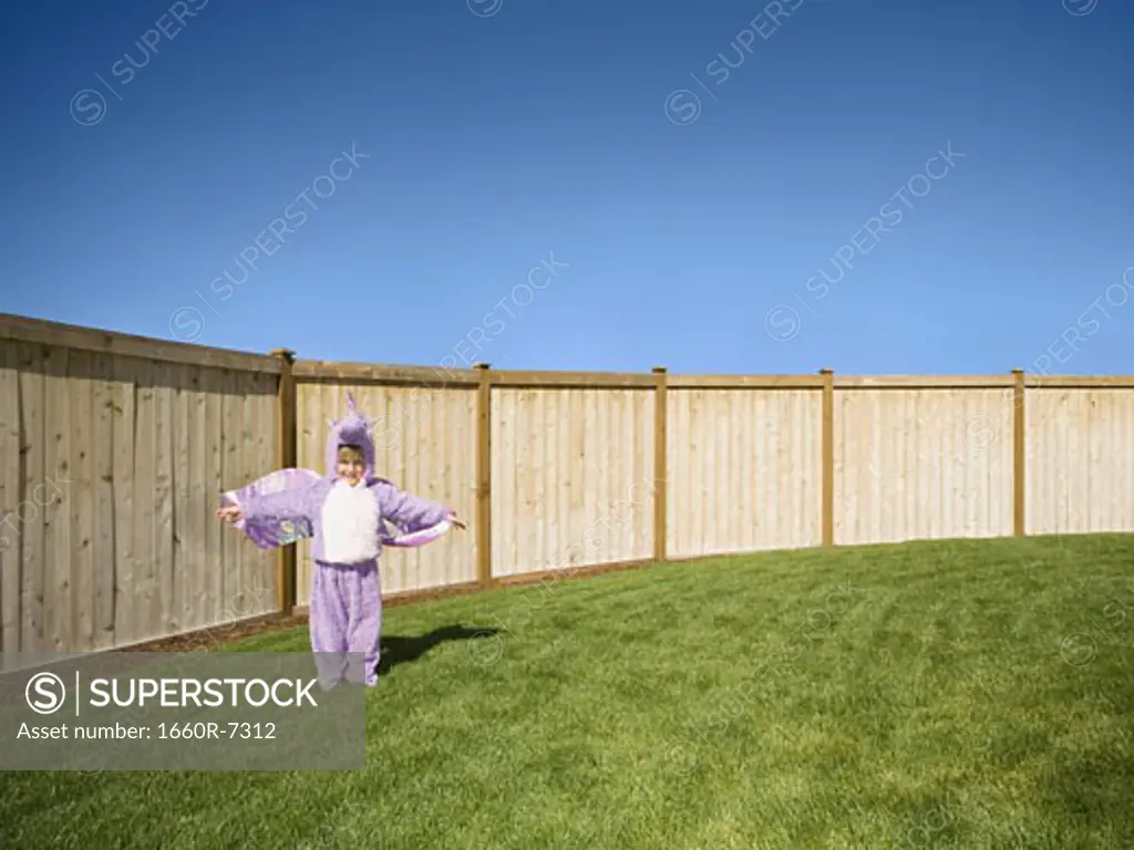 Girl in a costume standing in the backyard of her house