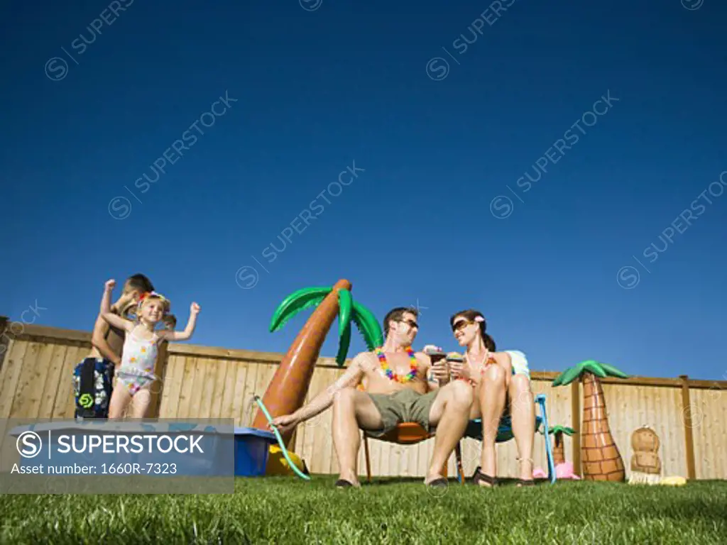 Low angle view of parents with their children playing in a wading pool