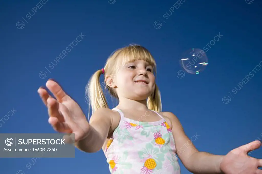 Low angle view of a girl catching a bubble