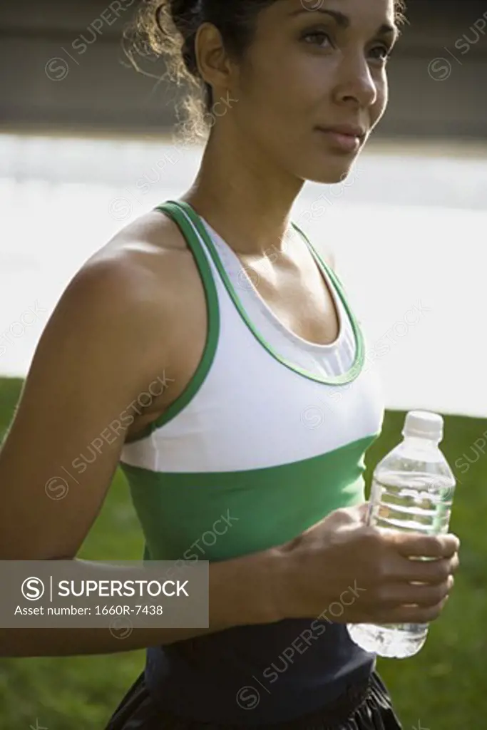 Profile of a woman holding a water bottle and thinking