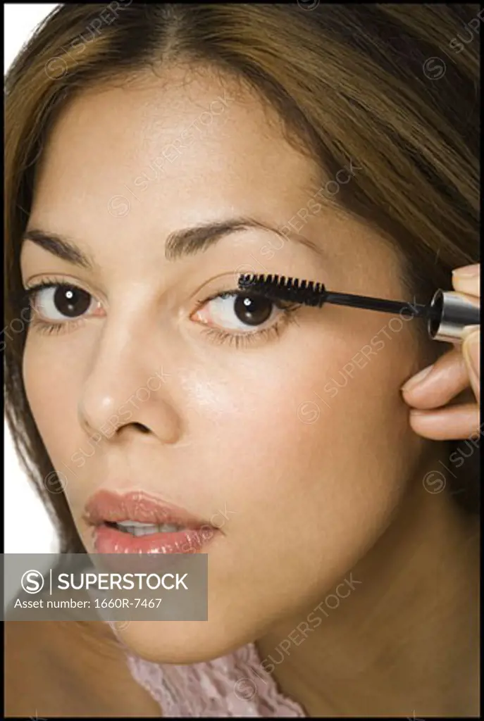Portrait of a woman applying mascara on her eyelashes
