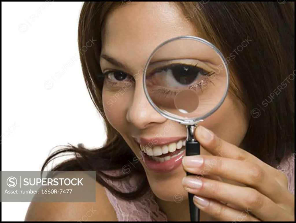 Portrait of a woman looking through a magnifying glass
