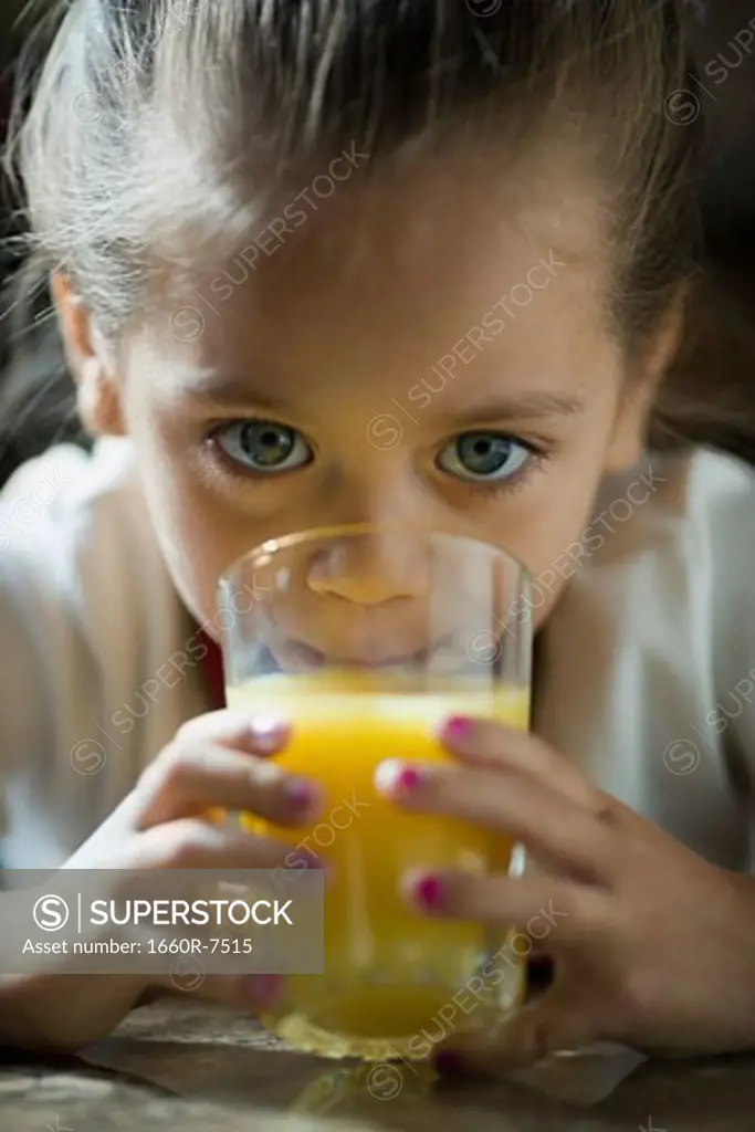 Portrait of a girl drinking a glass of juice