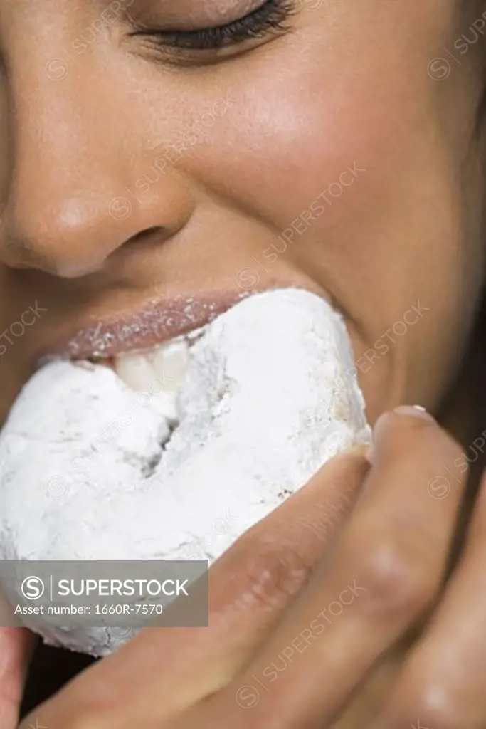 Close-up of a young woman eating a donut