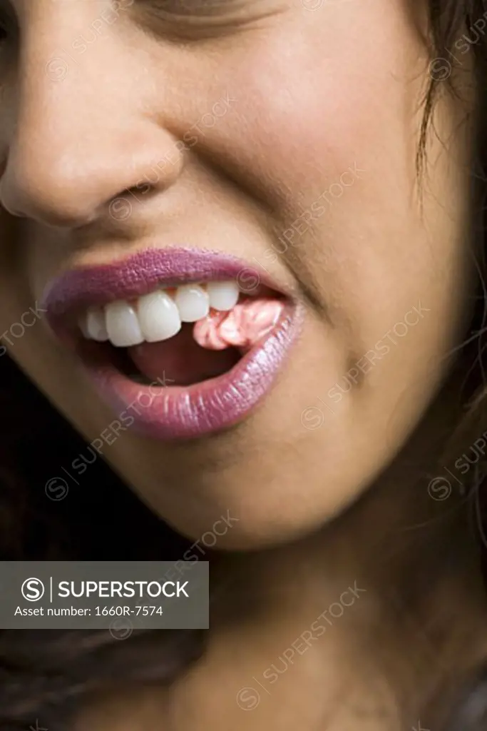 Close-up of a young woman chewing a bubble gum