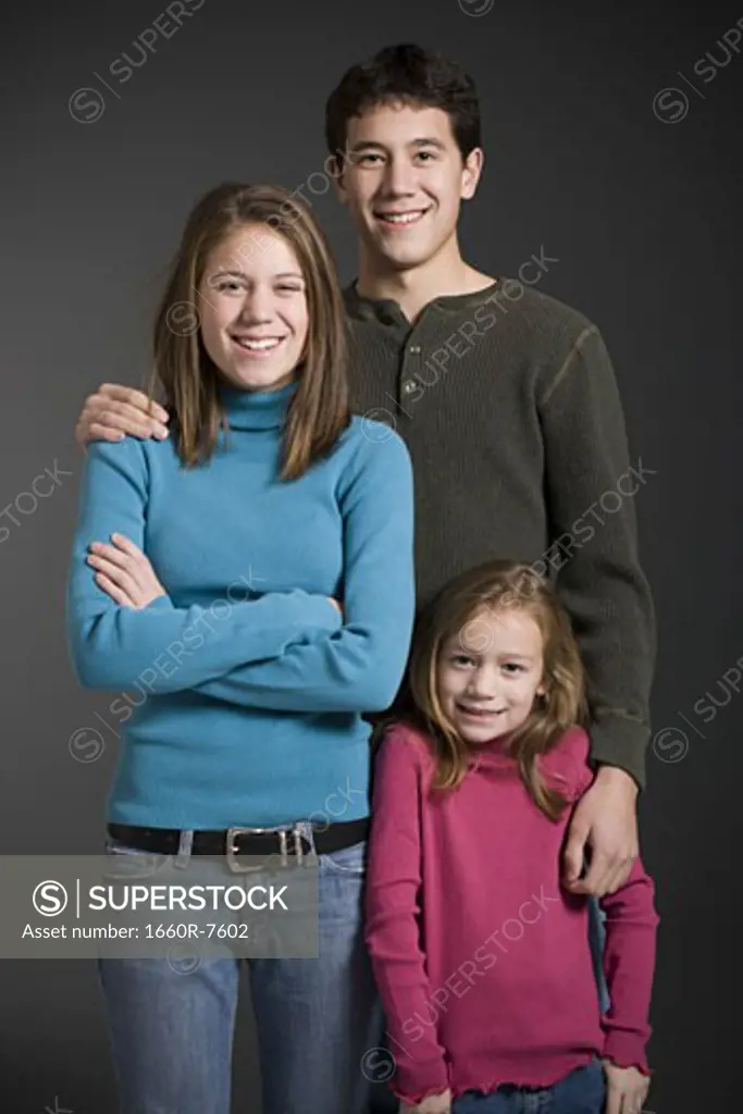 Portrait of two parents standing with their daughter and smiling