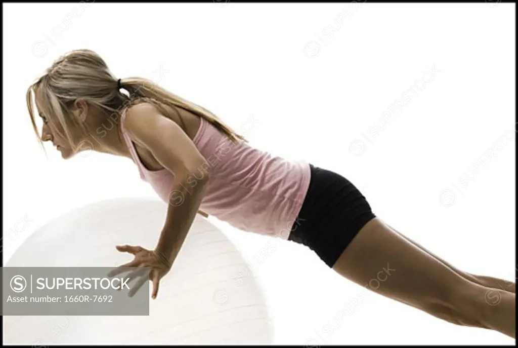 Profile of a young woman exercising on a fitness ball