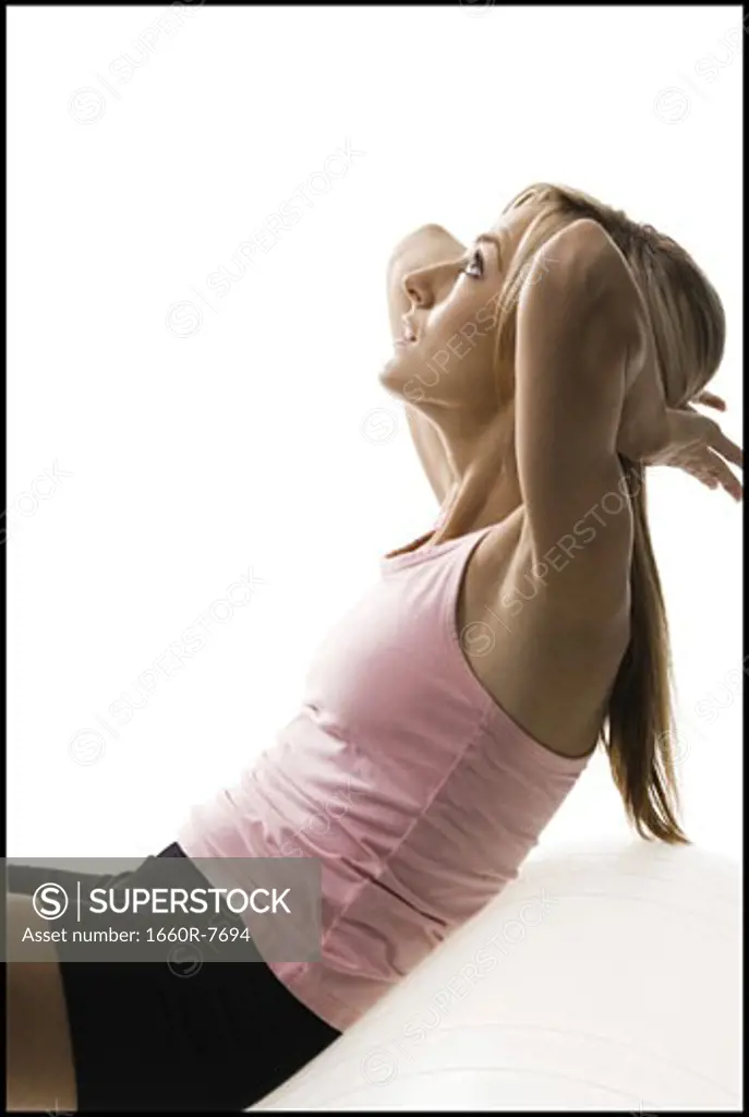Profile of a young woman exercising on a fitness ball