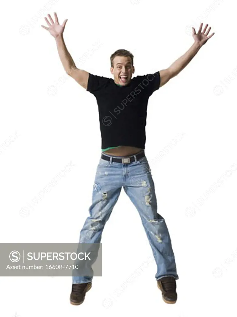 Portrait of a young man jumping with his arms outstretched