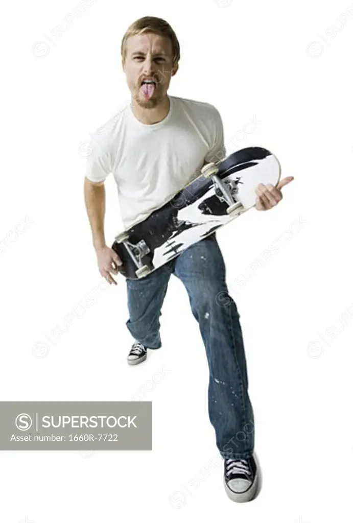 Portrait of a young man holding a skateboard like a guitar
