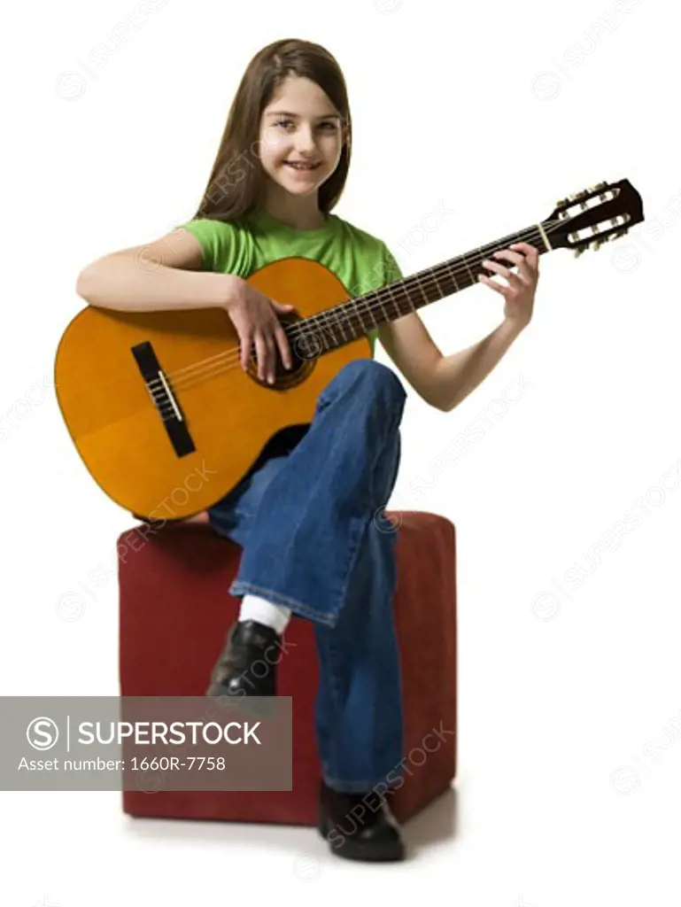 Portrait of a teenage girl playing the guitar