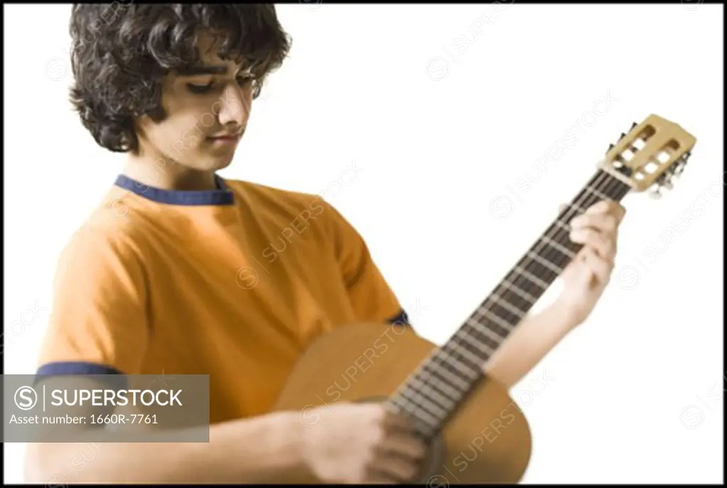 Close-up of a teenage boy playing the guitar
