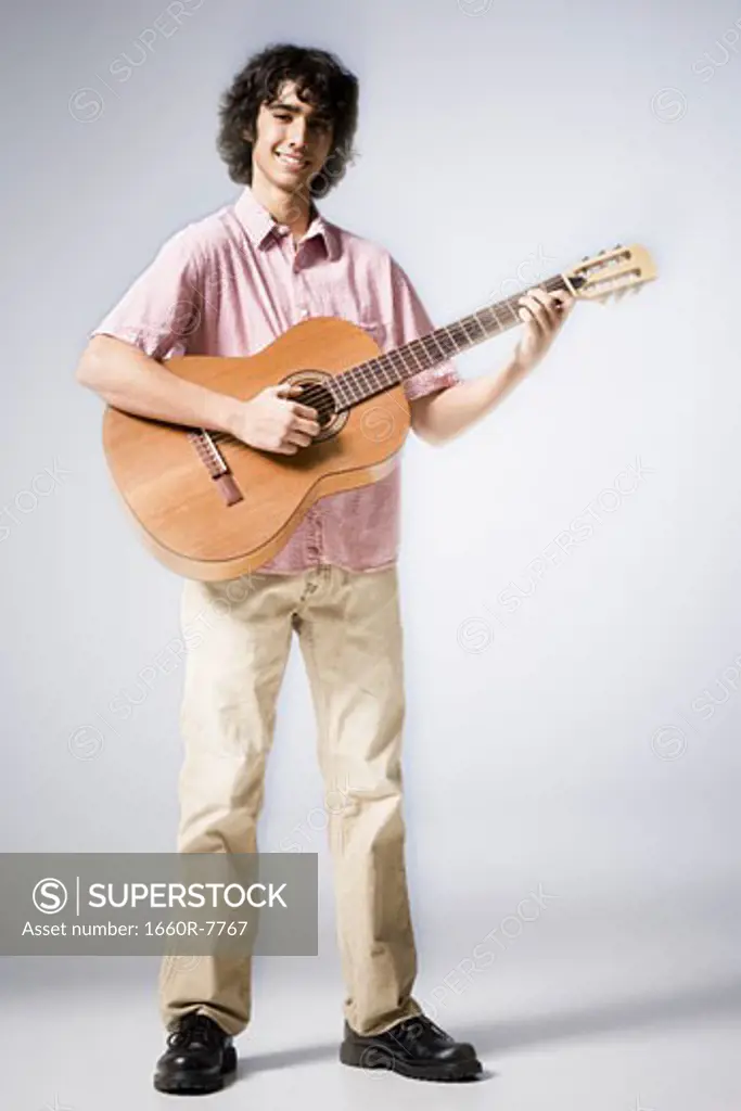 Portrait of a teenage boy playing the guitar