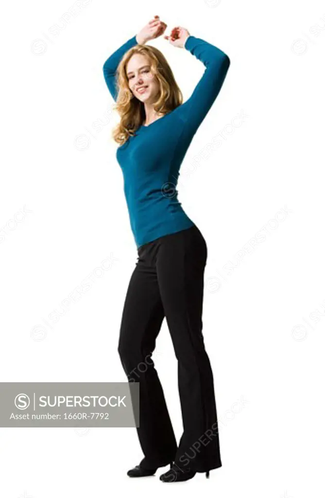 Portrait of a young woman standing with her arms raised