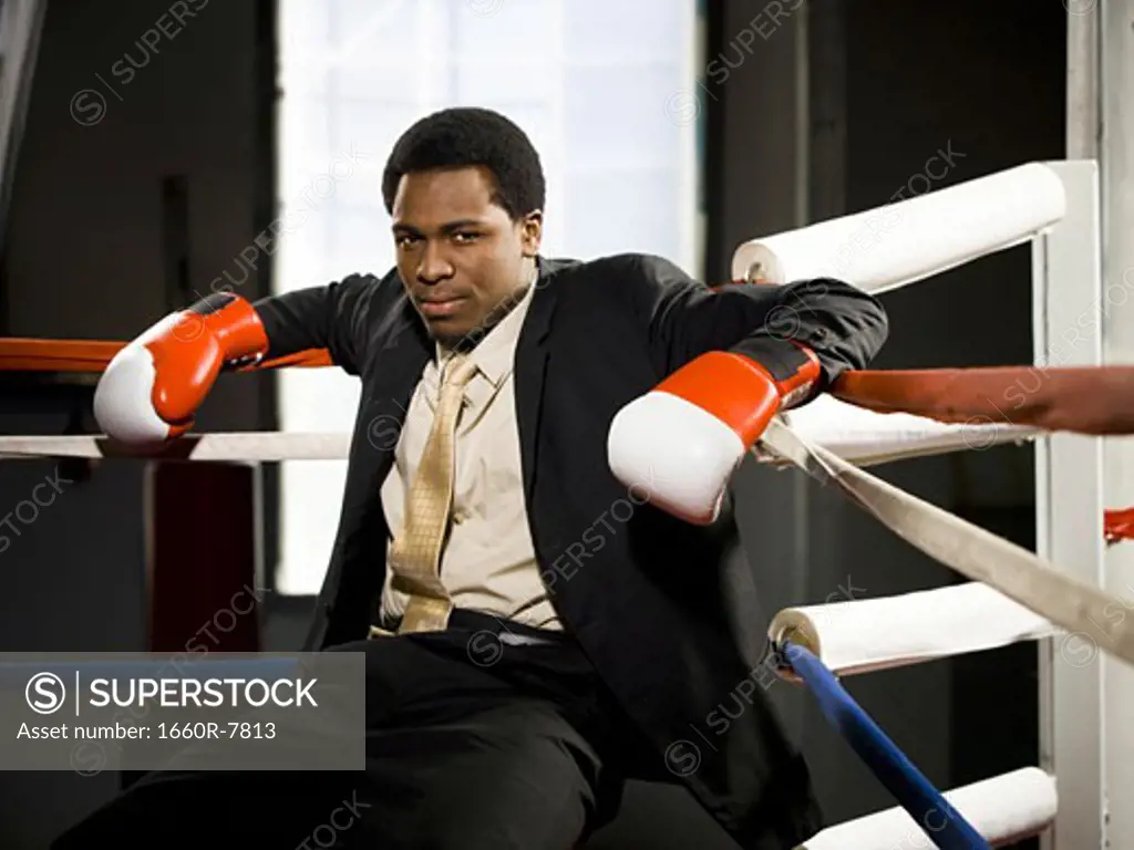 Portrait of a businessman sitting in a boxing ring