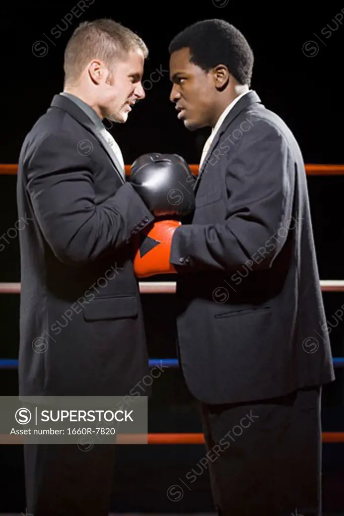 Profile of two businessmen staring at each other in a boxing ring