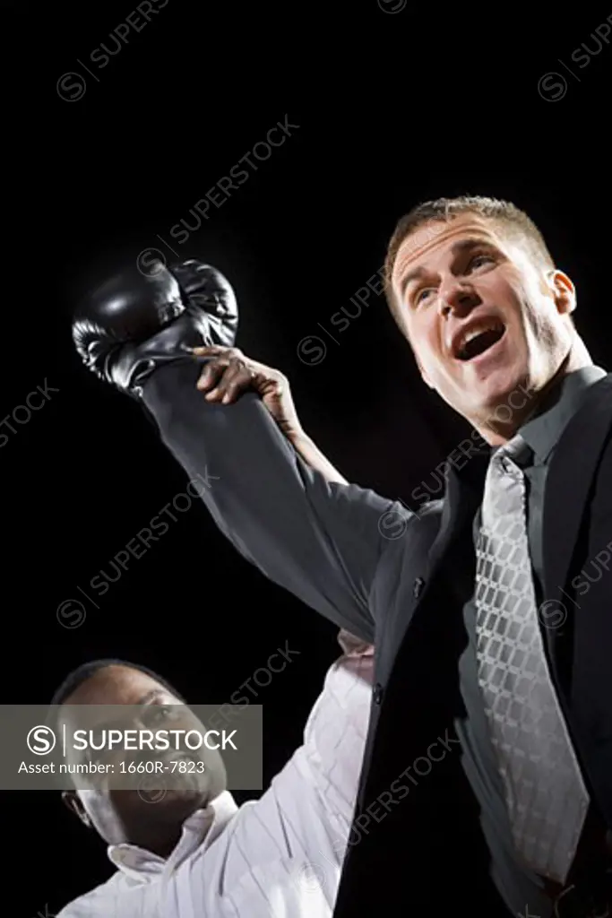 Low angle view of a referee declaring the winner of a boxing match