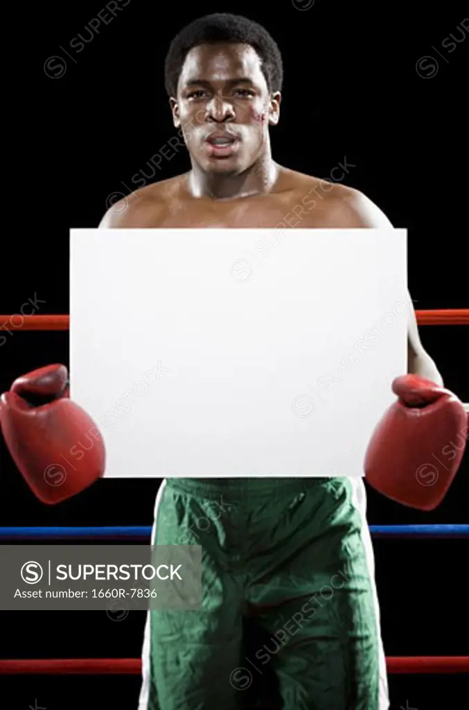 Portrait of a male boxer holding a blank sign