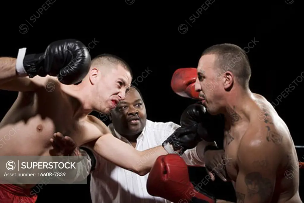 Referee separating two boxers during a fight