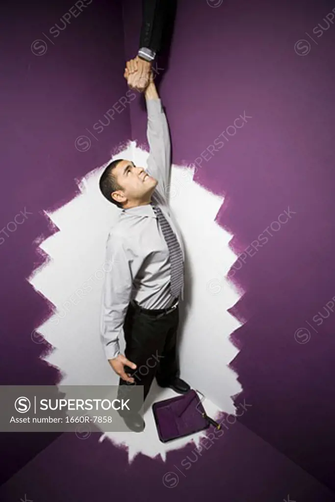 High angle view of a businessman reaching out for a man's hand