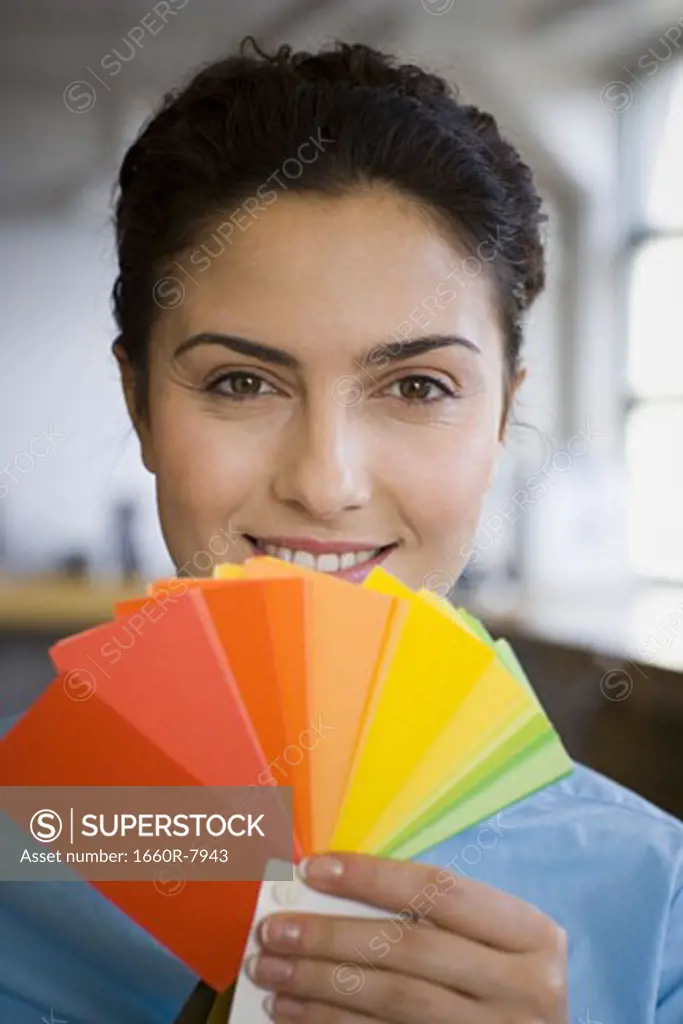 Portrait of a young woman holding color swatches