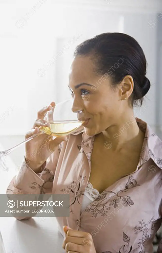Close-up of a young woman enjoying a glass of white wine