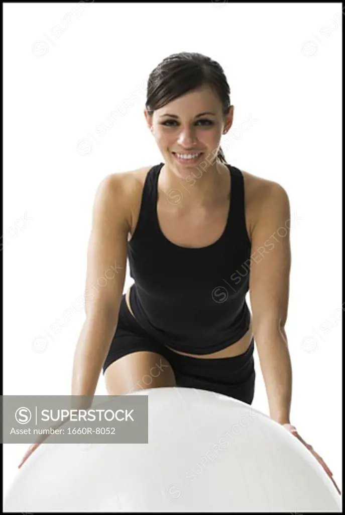 Portrait of a woman leaning on a fitness ball