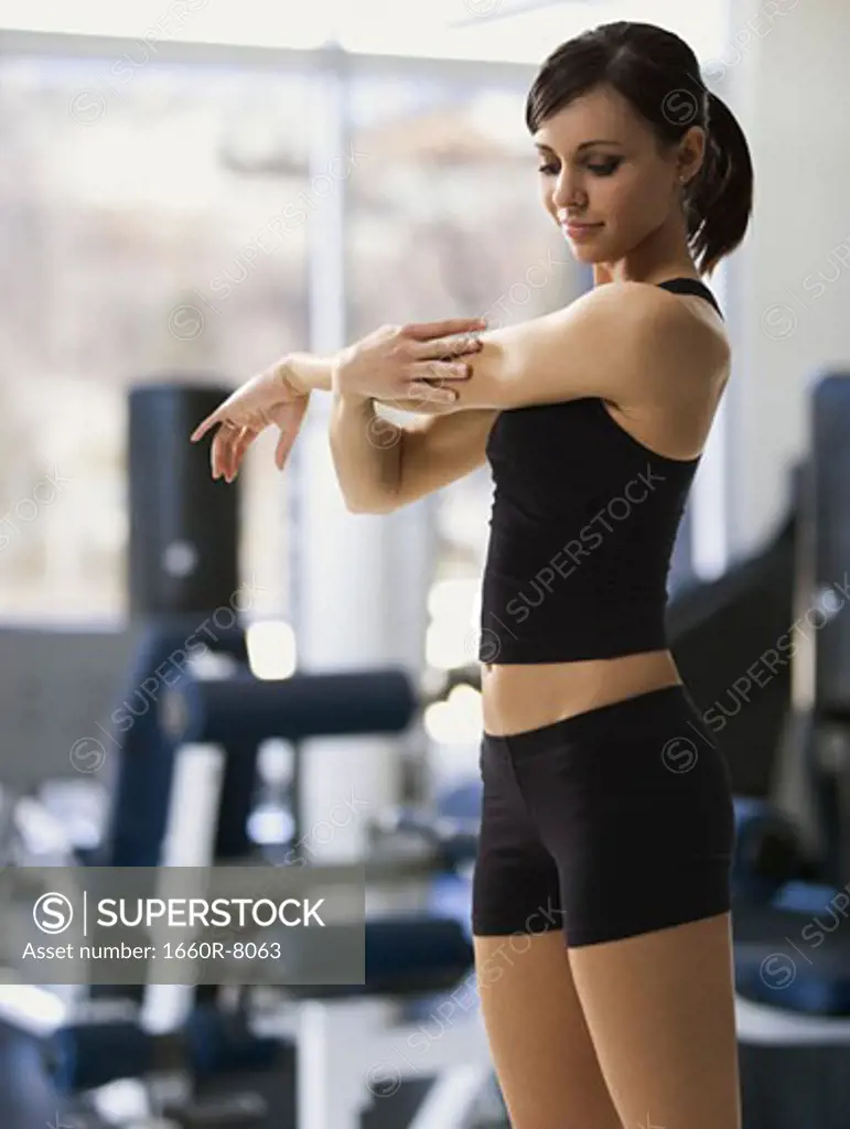 Profile of a woman stretching in a gym