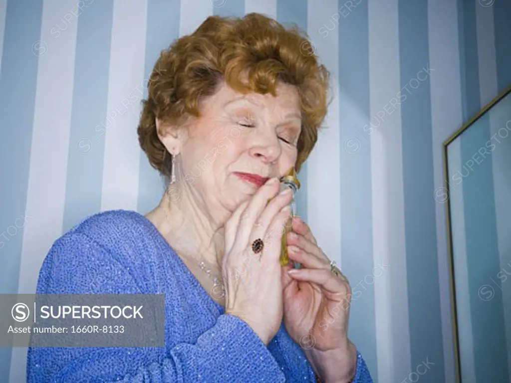 Close-up of a senior woman smelling perfume