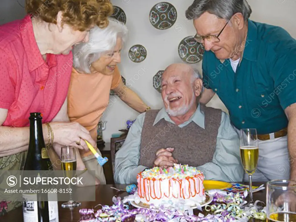 Two senior couples smiling at a birthday party
