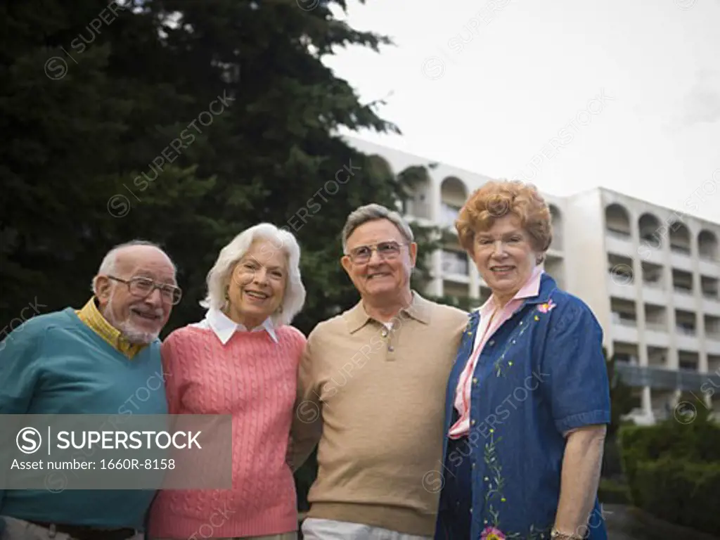 Portrait of two senior couples smiling together with their arms around each other