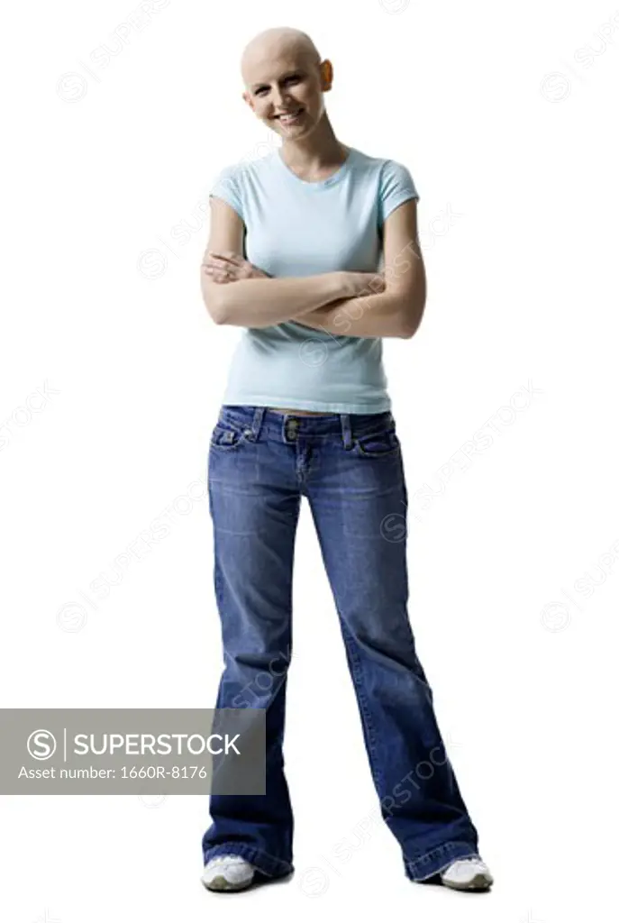Portrait of a bald young woman standing with her arms crossed