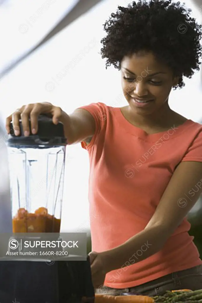 Close-up of a young woman using a blender